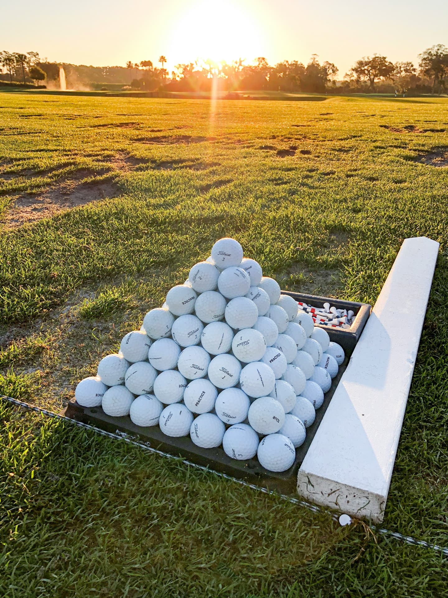 Range balls stacked at sunset on a driving range
